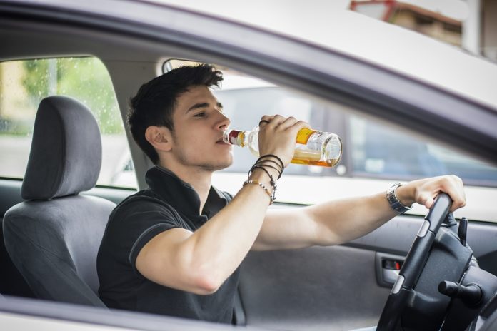 omul bea alcool în timp ce conduce