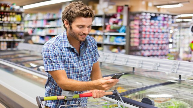 un bărbat cu telefon într-un supermarket